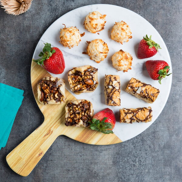 An Elite Global Solutions Sierra faux alder wood and marble melamine serving board with food on it.