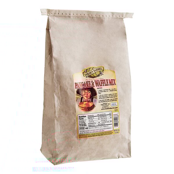 A brown bag of Golden Barrel Premium Pancake & Waffle Mix with a label showing a woman.