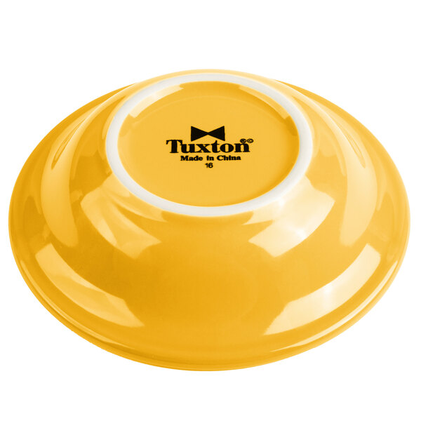 A yellow Tuxton monkey dish with a white rim.