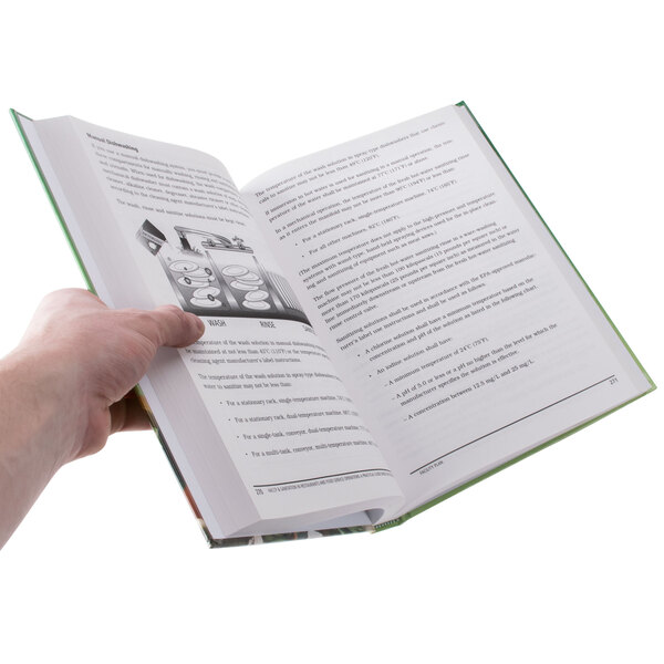 A close-up of a hand holding an open book with a white background.