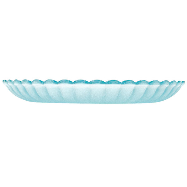 A clear polycarbonate plate with a scalloped edge on a blue surface.