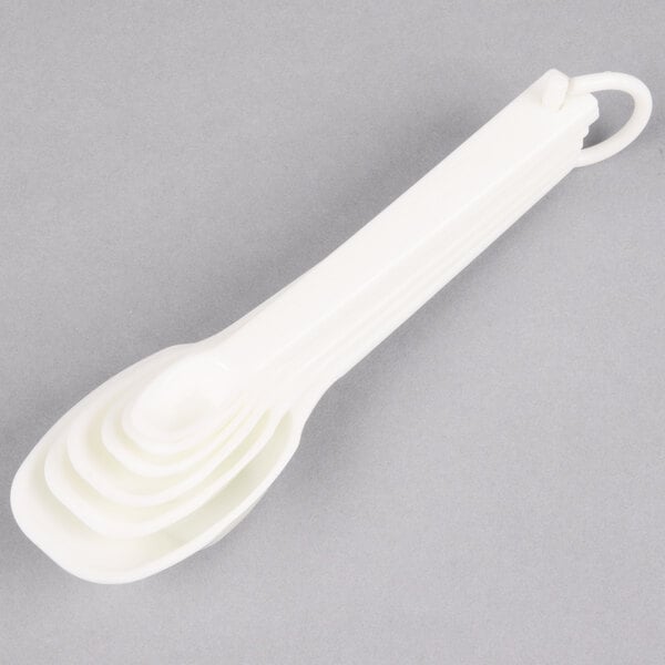 A group of white plastic Rubbermaid measuring spoons.