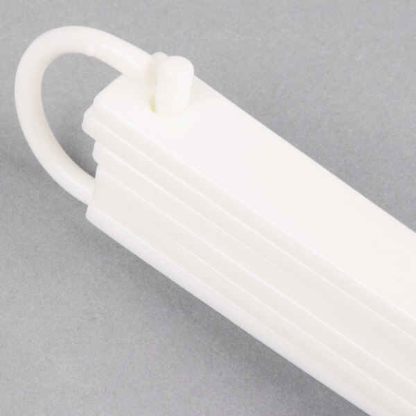 A white plastic Rubbermaid measuring spoon set with a handle.