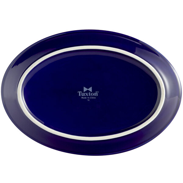 A cobalt blue oval china platter with a white border.