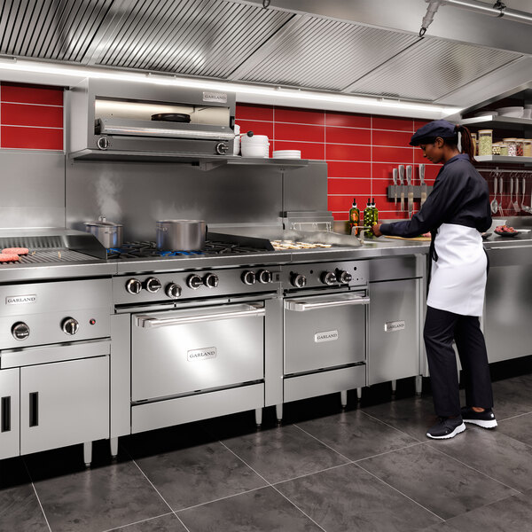 A Garland natural gas salamander broiler mounted on a stainless steel range.