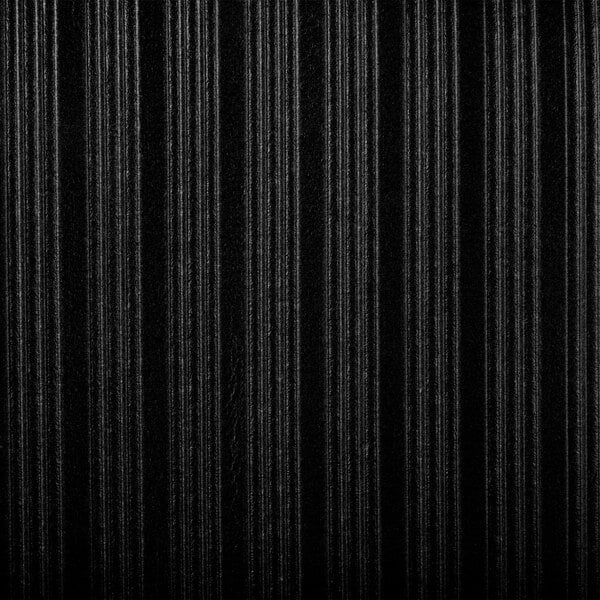 A close-up of a black ribbed surface on a Cactus Mat Tredlite anti-fatigue mat.