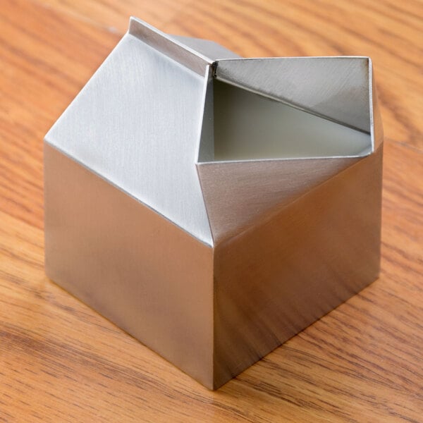 An American Metalcraft stainless steel milk carton creamer on a wood surface.