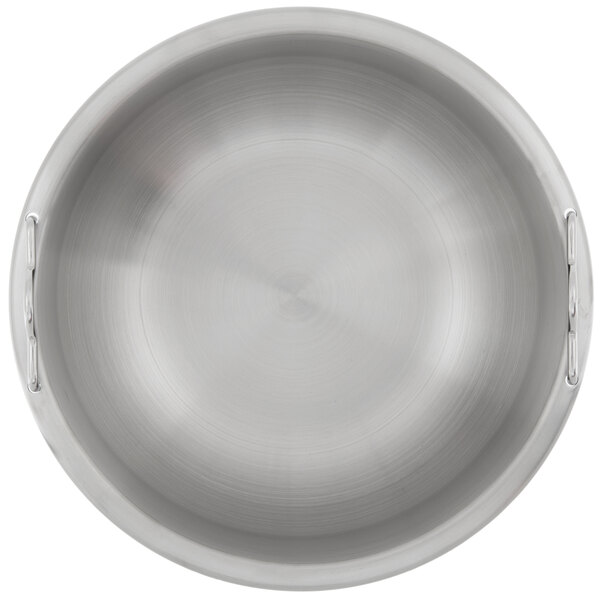A close-up of a silver stainless steel pan with a circular design and a handle.