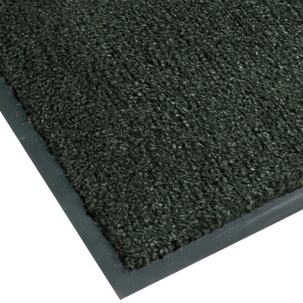 A close-up of a black Notrax carpet with a grey border.