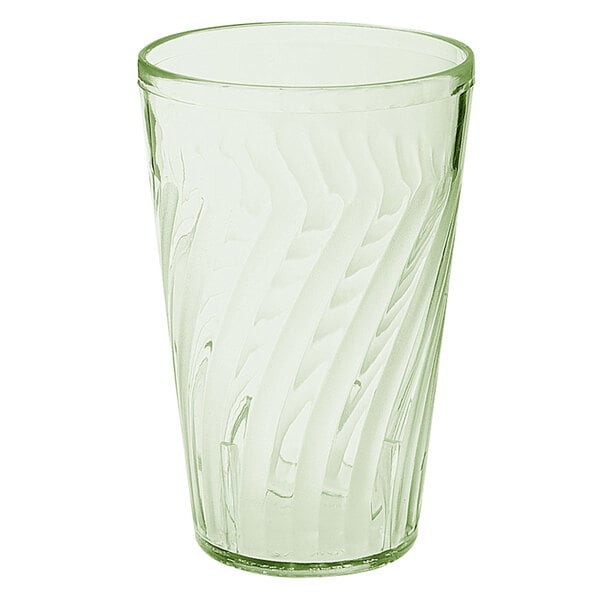 A clear glass with a green liquid in it.
