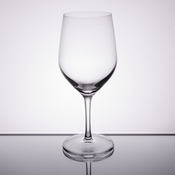 A Stolzle clear wine glass on a reflective surface.
