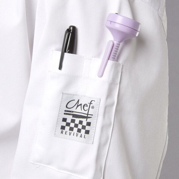 A close-up of a white Chef Revival chef coat pocket with a purple pen and pen holder.