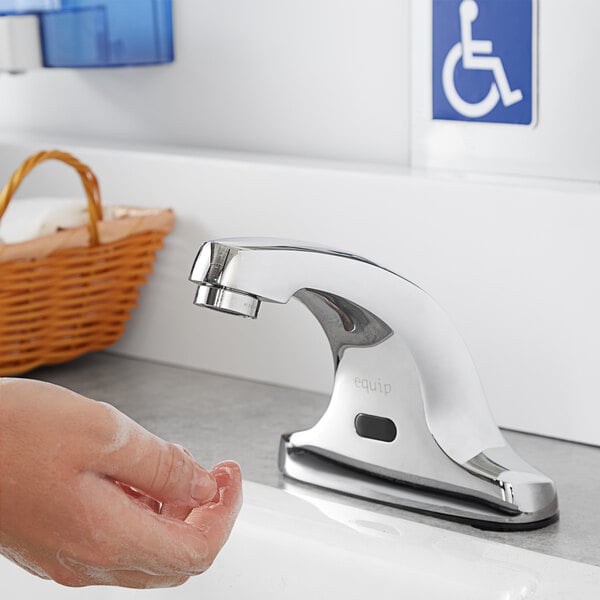 A person using an Equip by T&S hands-free faucet to wash their hands.