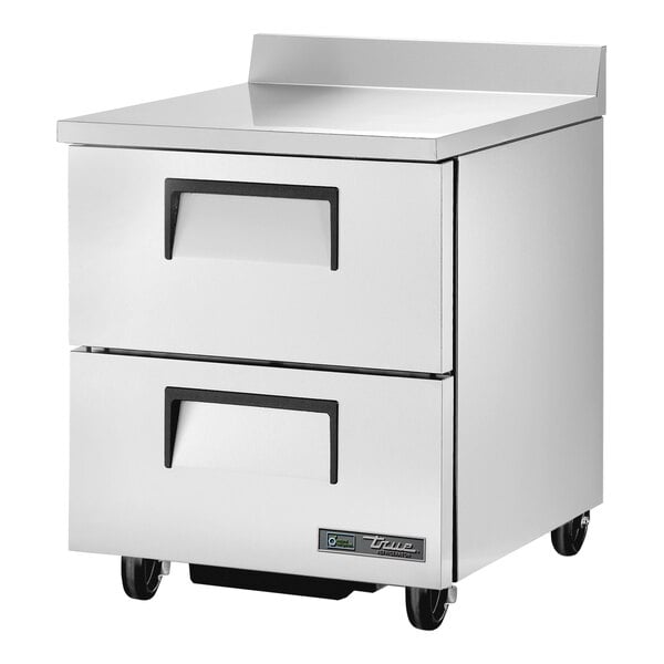 A stainless steel True worktop refrigerator with black wheels.