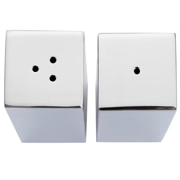 A pair of rectangular stainless steel salt and pepper shakers with holes in the top.