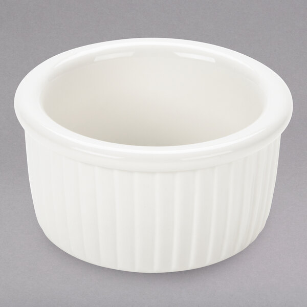 A white bowl with ridges sits on a table.
