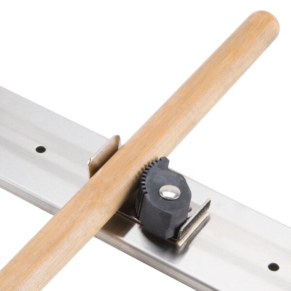 A stainless steel T&S mop hanger with a metal rail and black rubber grips.