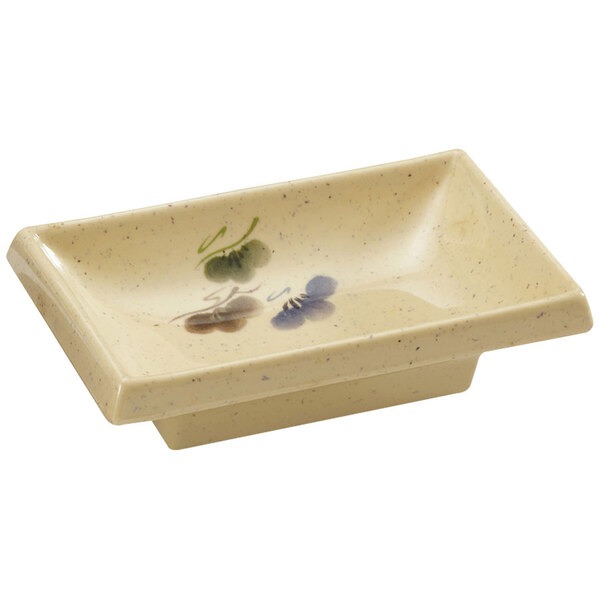 A rectangular GET Tokyo melamine sauce dish with a flower design.