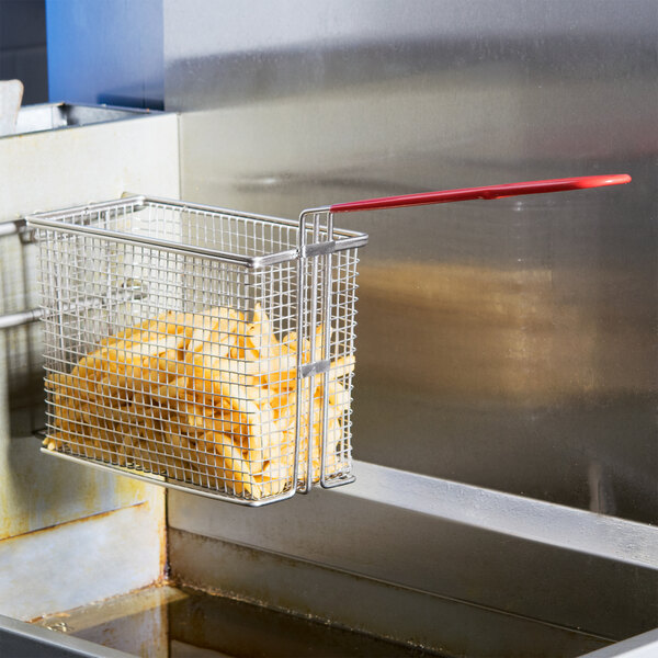 A Cecilware twin fryer basket with food inside of it resting on a counter.