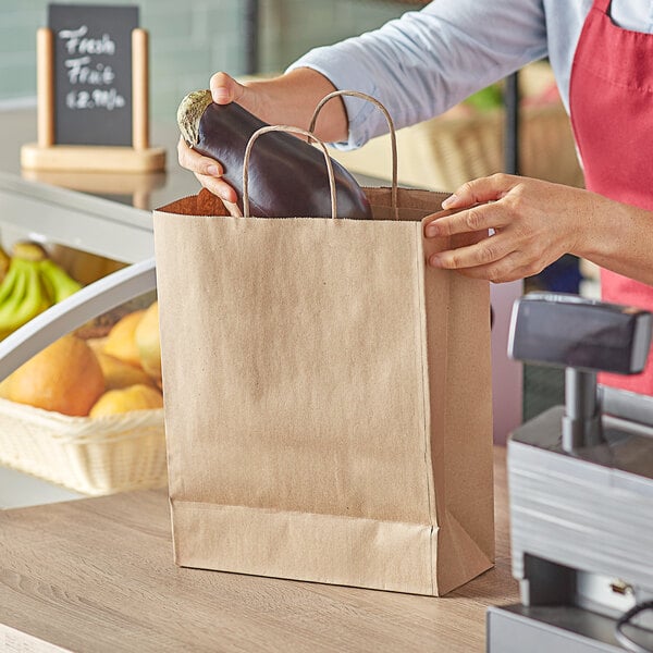 A woman holding a Duro natural Kraft paper shopping bag with a bottle of juice inside.