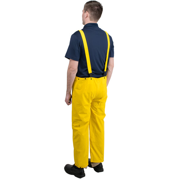 A man wearing yellow Cordova StormFront rainsuit pants and suspenders.