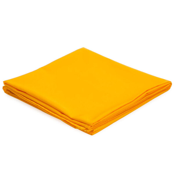 A folded gold Intedge poly/cotton blend table cover.