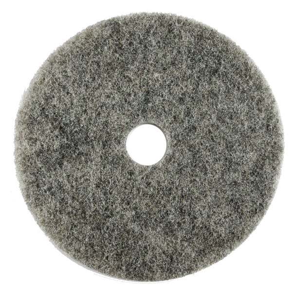 A grey circular Scrubble light burnishing floor pad with a hole in the middle.