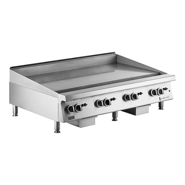 A large stainless steel 48-inch natural gas countertop griddle with multiple thermostatic controls and sturdy legs.