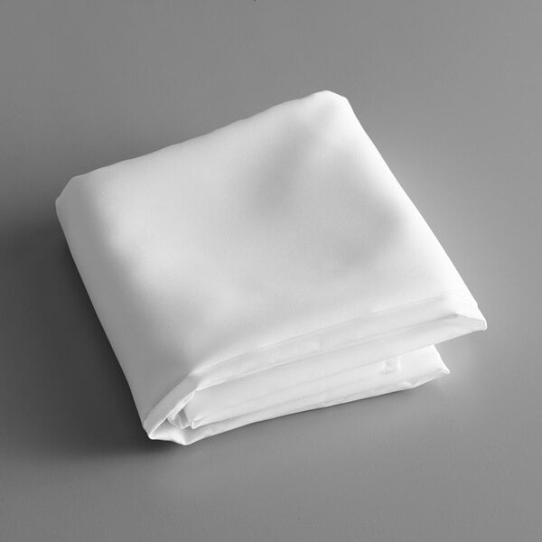 A folded white table cover on a gray surface.