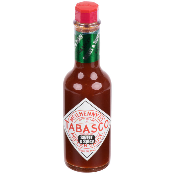 A close-up of a TABASCO® 5 oz. bottle of Sweet & Spicy Hot Sauce with a green label.