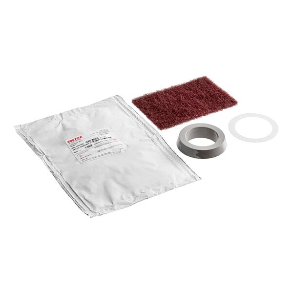 A white package with a red label and a brown sponge with a red lid.