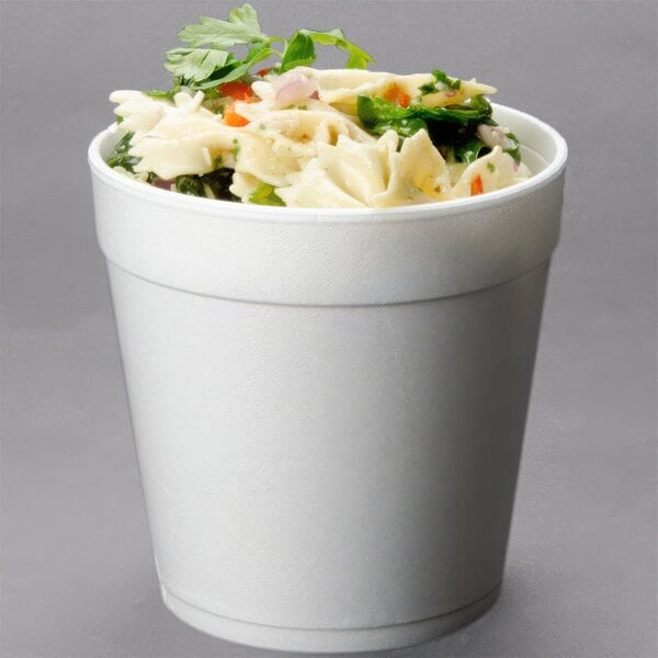 A Dart white foam food container filled with pasta and vegetables.