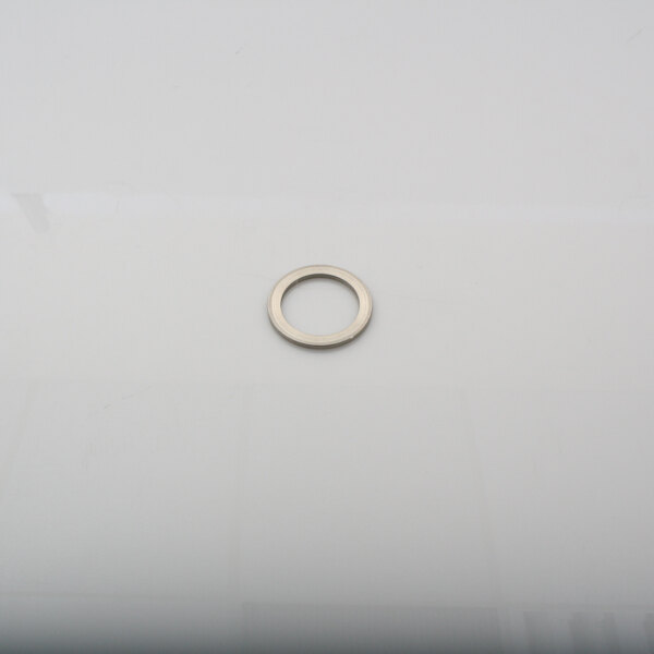 A silver circular spacer disk on a white surface.