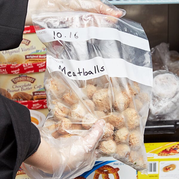 A person holding a LK Packaging resealable bag of meatballs.