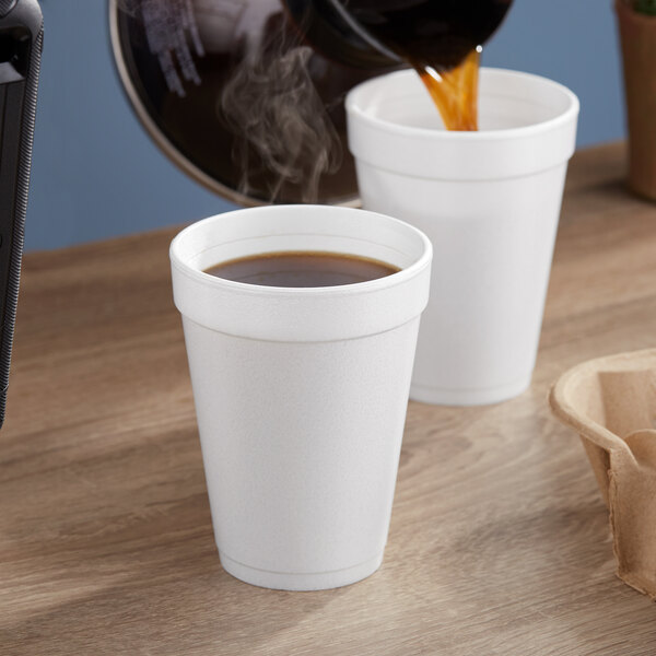 Two Dart white foam cups of coffee being poured