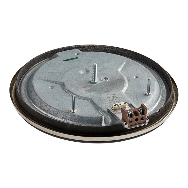 A round metal plate with a hole and screws.