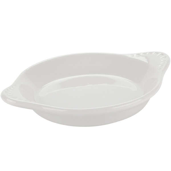 A white round shirred egg dish with a handle.