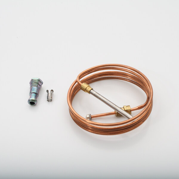A close-up of a copper pipe with a brass connector and a screw.