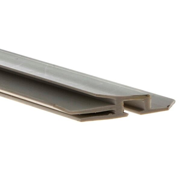 A close-up of a white plastic profile with two holes.