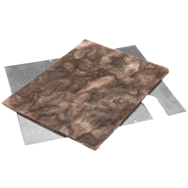 A brown felt pad on a white surface with gray material underneath.