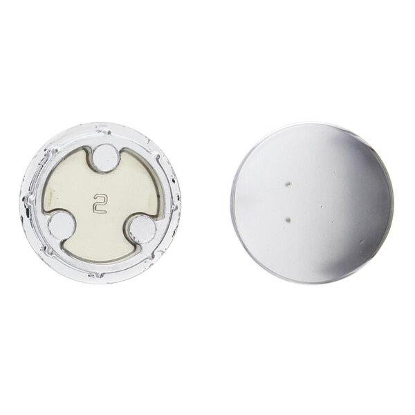 A close-up of two silver buttons on a white circular end stop.