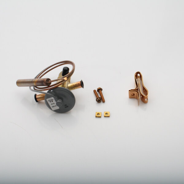 A close-up of a gold Master-Bilt expansion valve with a screw.