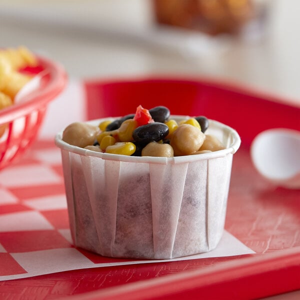 A red tray with a Genpak Harvest white souffle cup of food.