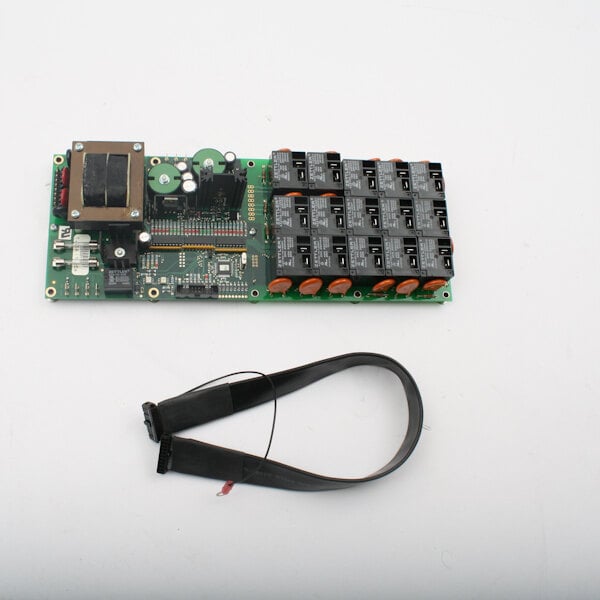 A green Groen circuit board with black wires and a black strap.