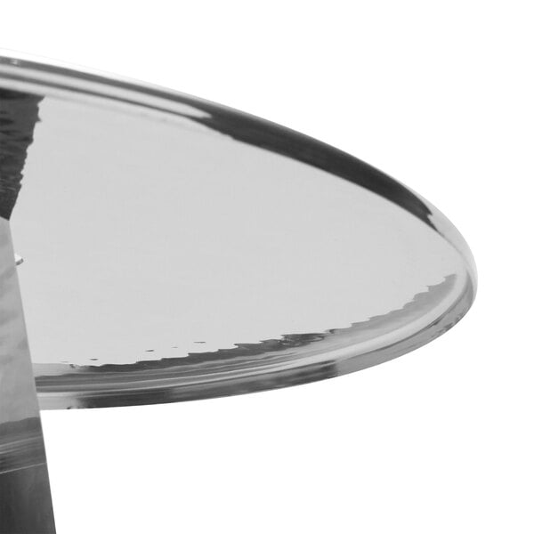 An American Metalcraft stainless steel 3 tier display stand on a table with a glass top.