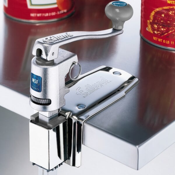 An Edlund U-12 L heavy duty manual can opener on a metal counter.