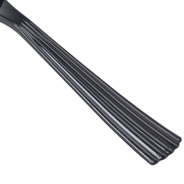 A close up of a WNA Comet Classicware EcoSense black plastic spoon with a handle.