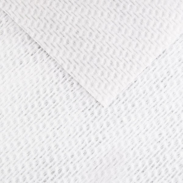 A close-up view of a white, textured, nonwoven fabric with a subtle diagonal pattern.