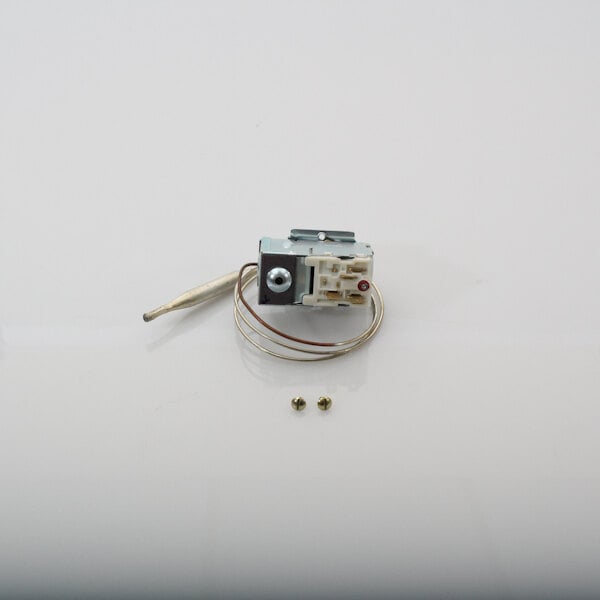 A Jackson thermostat with a small metal piece and wire screws.