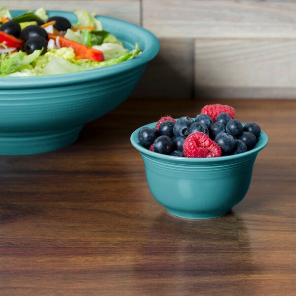 A bowl of salad with fruit in it served in a Fiesta Turquoise China Bouillon bowl.